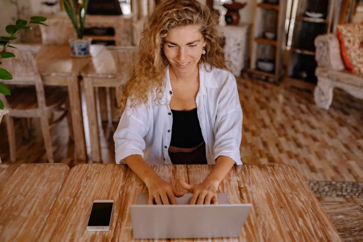 Mujer trabajando en su página web con el portátil y el móvil
